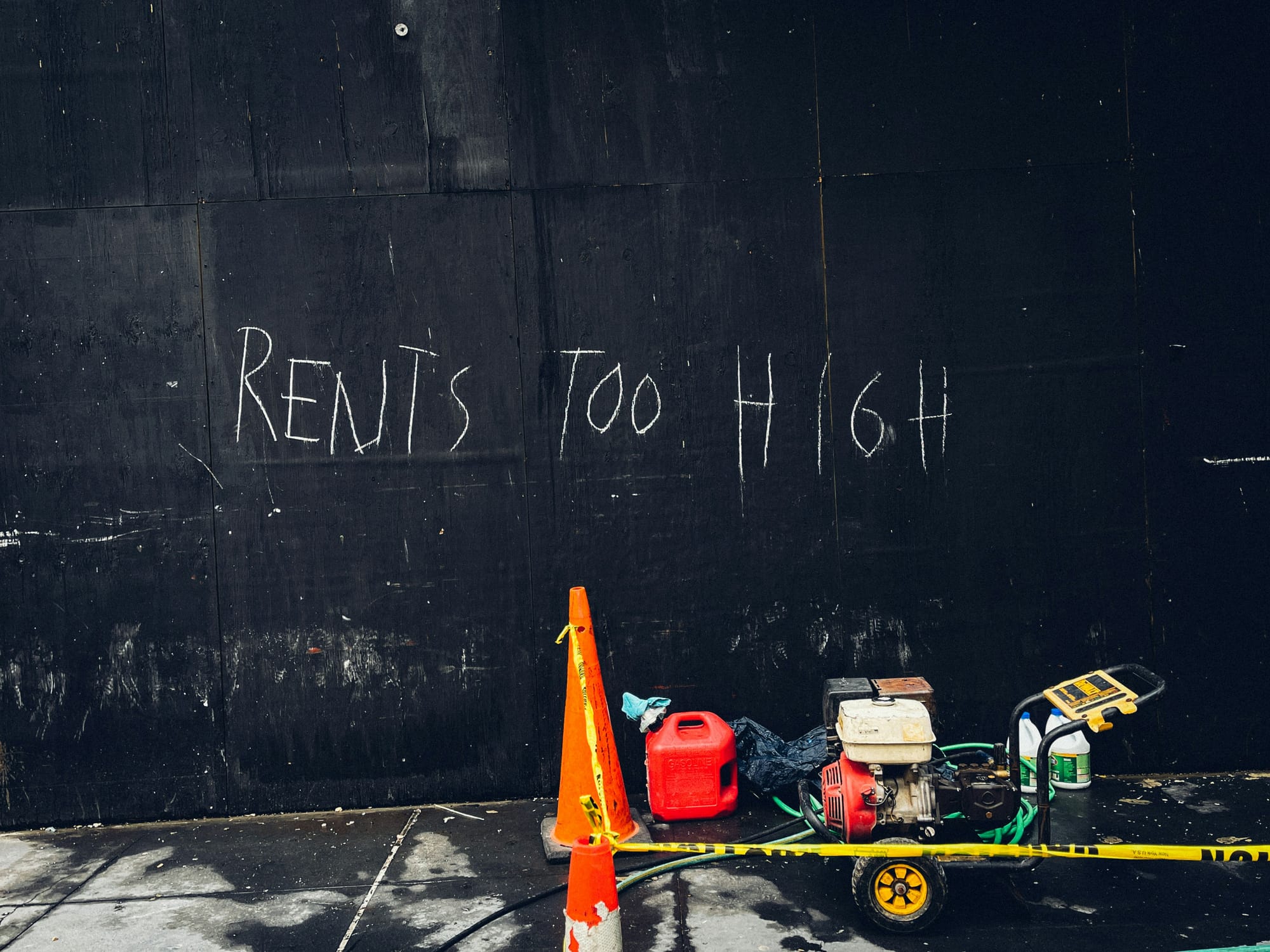 Rents too high sign on black wall