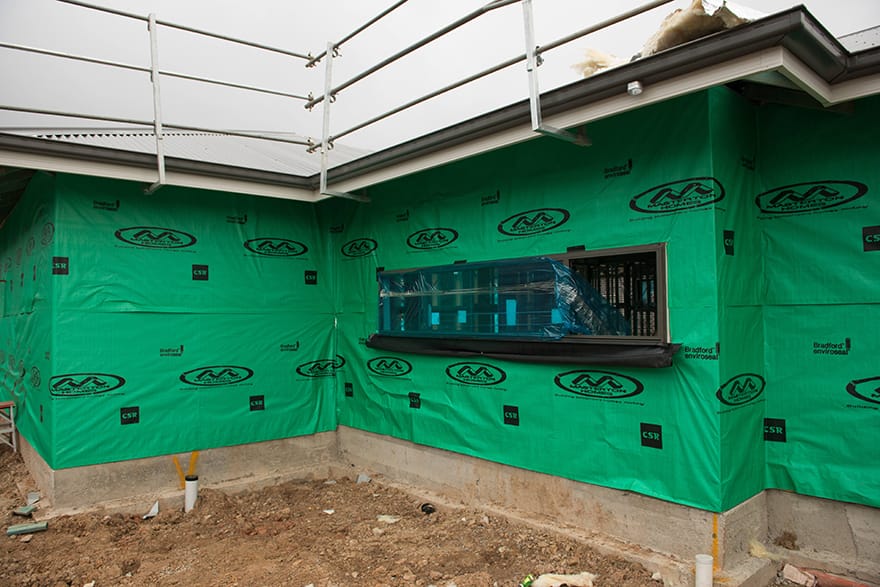A house under construction showing wall wrap poorly installed (non compliant)