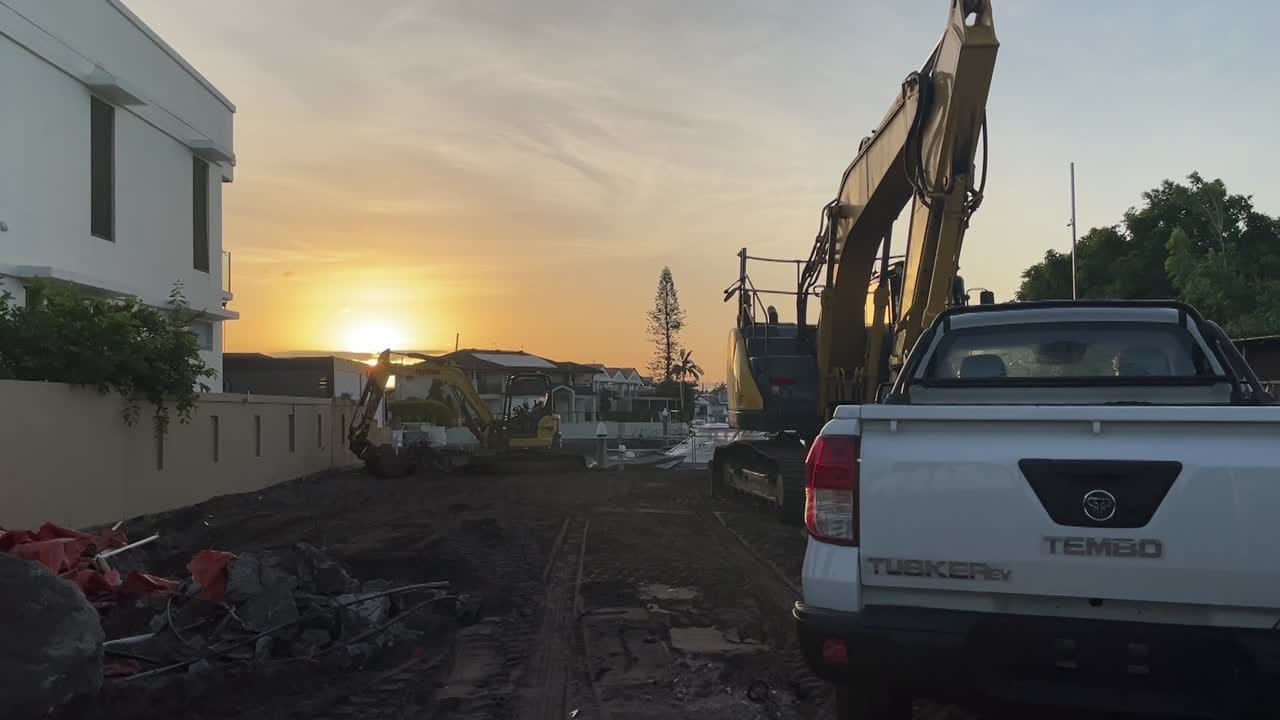 Ground-level photo of a fully cleared residential building block after demolition, showing flat ground and temporary fencing.